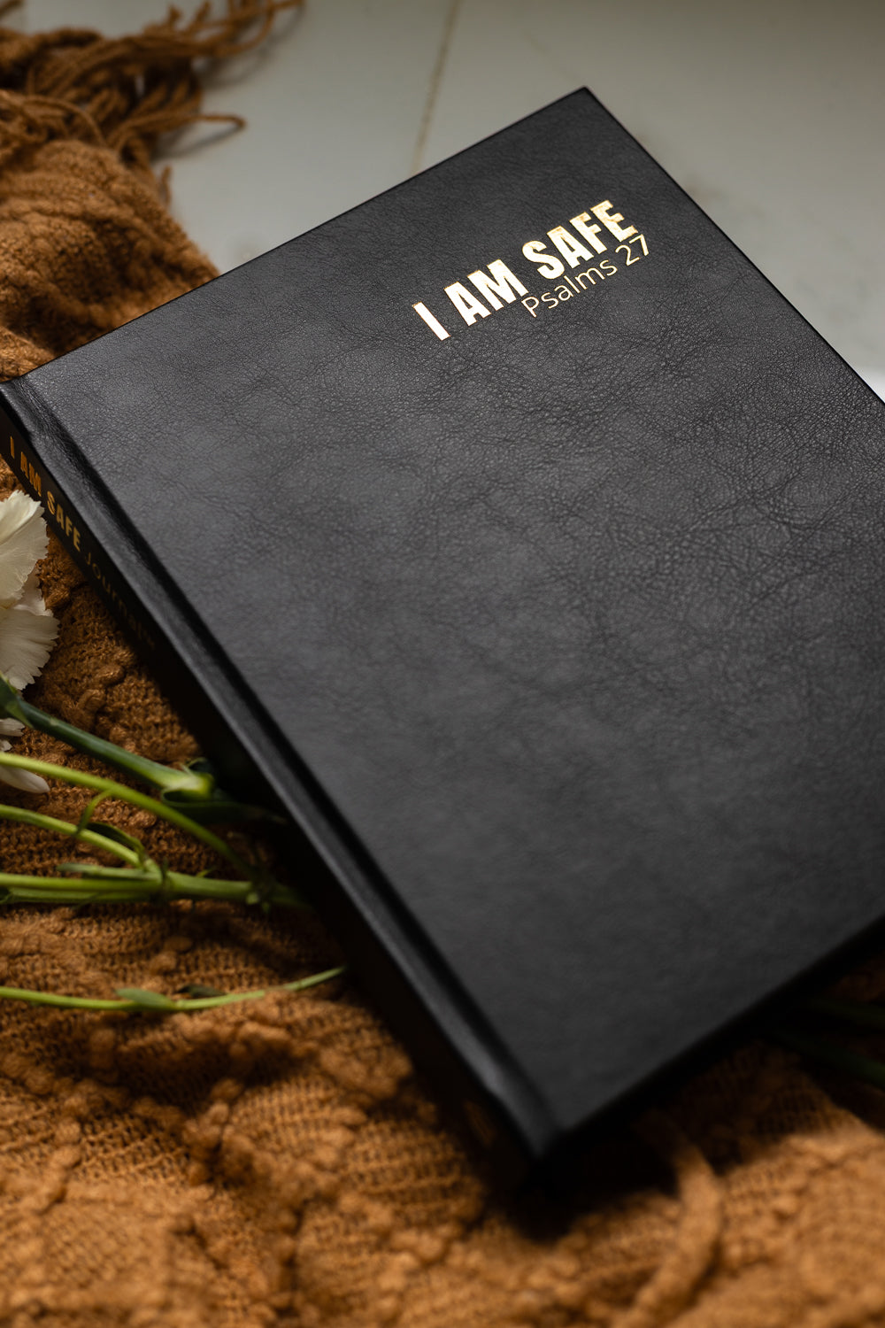 Black notebook with 'I AM SAFE' text on a textured surface