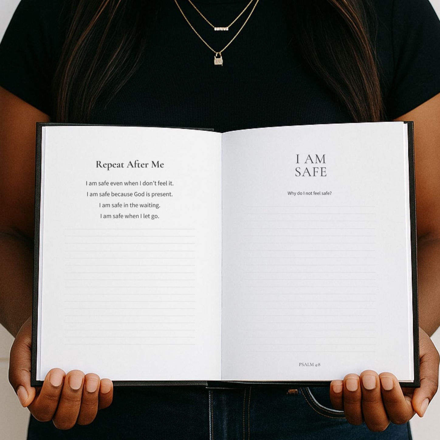 Person holding an open book titled 'I AM SAFE' with a white background