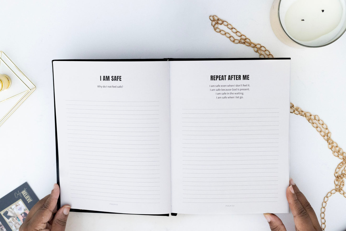 Open I AM SAFE Journal with affirmation text on a white surface with hands holding it