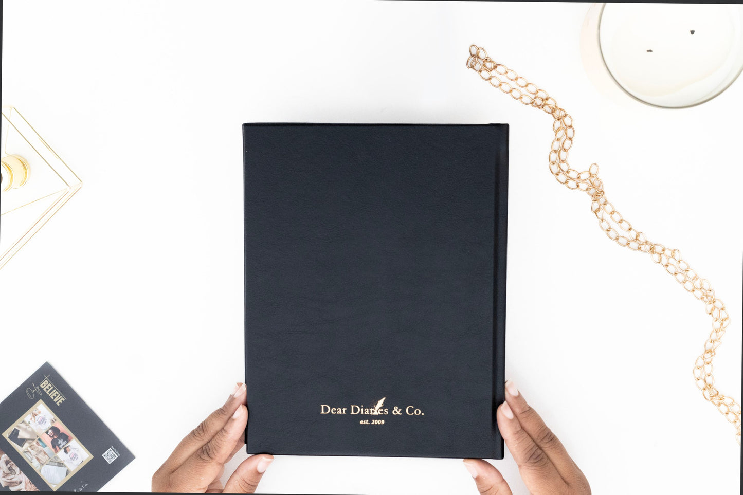 Minimalist back cover of the I AM SAFE journal with sleek, understated design. with 'Dear Diaries & Co.' branding held by hands on a white surface.