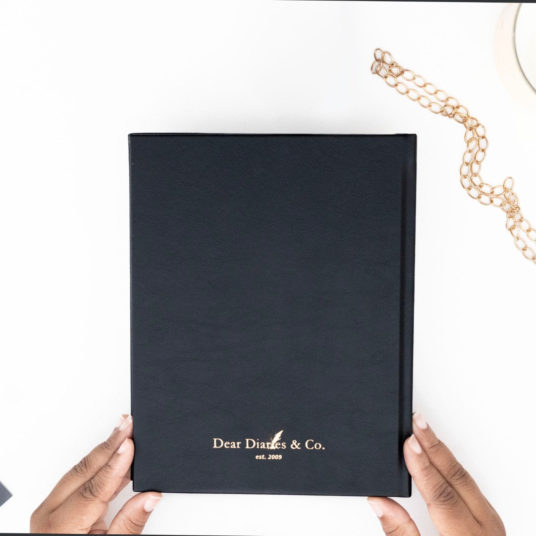 Minimalist back cover of the I AM SAFE journal with sleek, understated design. with 'Dear Diaries & Co.' branding held by hands on a white surface.