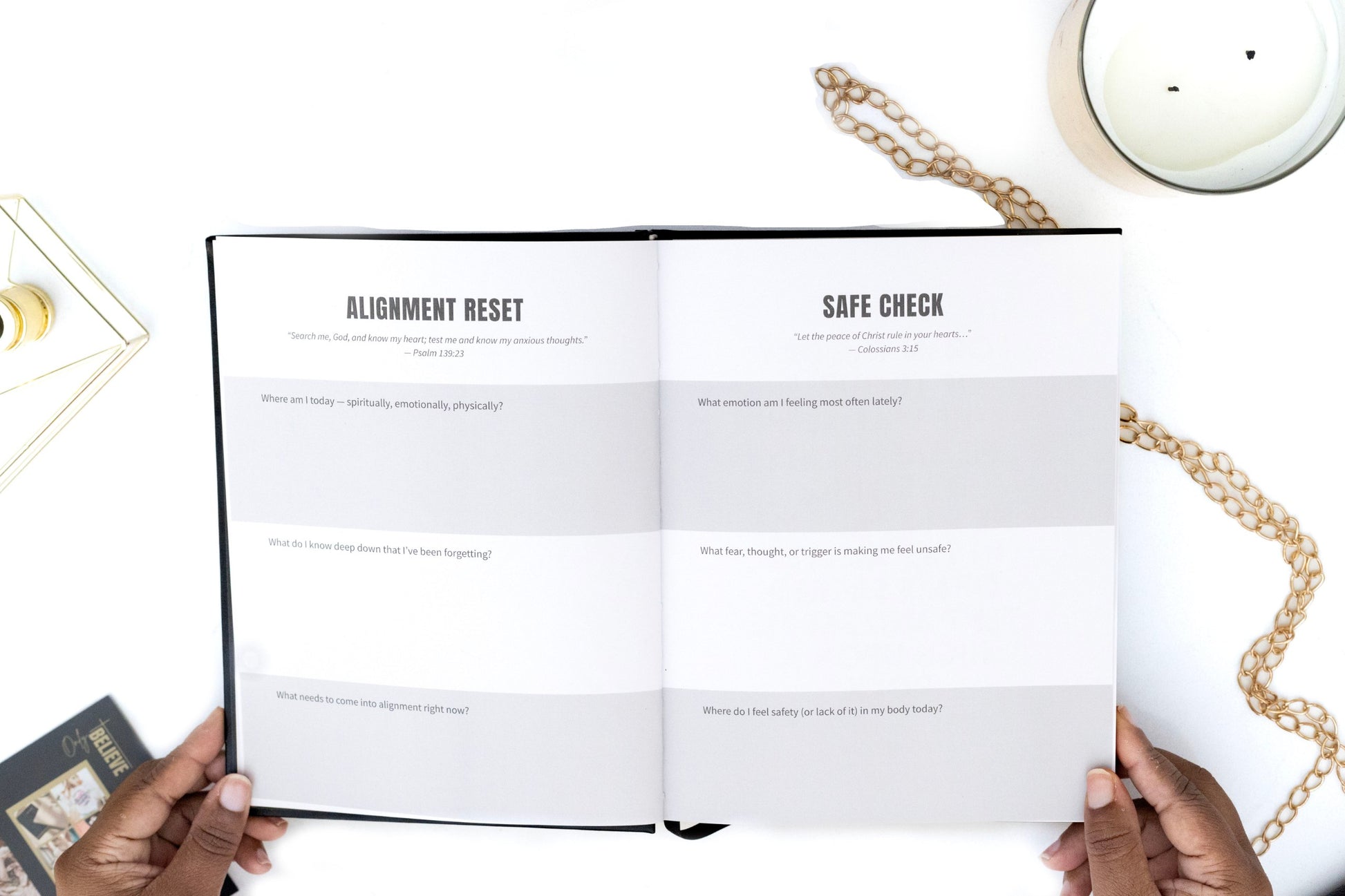 Open book of the I AM SAFE Journal with 'Alignment Reset' and 'Safe Check' sections on a white surface with a candle and chain.